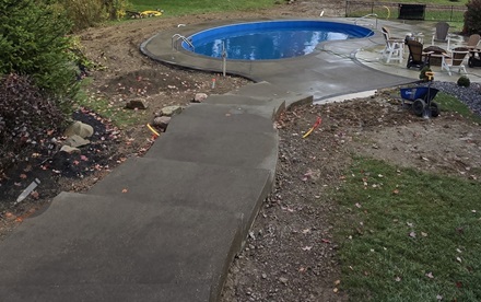 photo of formed concrete steps descending to a pool patio