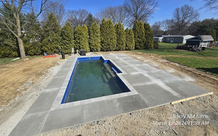 photo of a freshly finished concrete patio around a pool